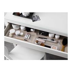 an open drawer with makeup and brushes in it