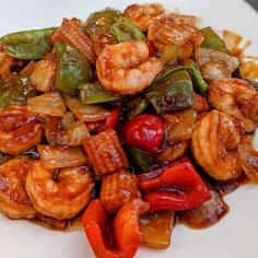 shrimp and peppers on a white plate with sauce