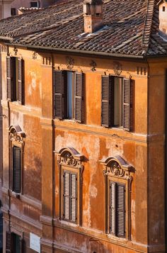 an old building with many windows and shutters on the top floor is seen from above