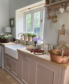 a kitchen filled with lots of pots and pans on top of a white counter