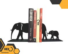 an elephant bookend is sitting on top of bookshelves with two elephants in the background