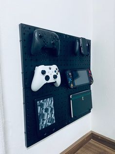 A picture of a pegboard holding some things like an xbox and nintendo controller and a sketchbook Pegboard Nintendo Switch, Gamer Pegboard, Pegboard Gaming Setup, Pegboard Gaming, Gamer Room Ideas Boy Bedrooms, Boys Gamer Bedroom Ideas, Small Gamer Bedroom, Office Pegboard, Boys Gaming Room