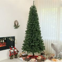 a living room with a christmas tree in the corner and other decorations on the floor