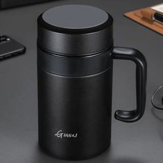 a black coffee mug sitting on top of a table