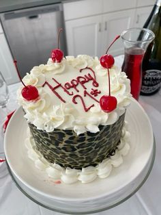 a birthday cake with white frosting and cherries