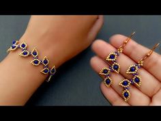 a woman's hand is holding two bracelets with blue beads and gold chains