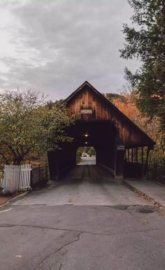 an old covered bridge in the middle of autumn