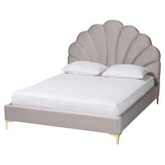 a white bed with an upholstered shell headboard