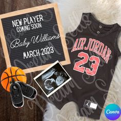 a baby's basketball jersey and shoes are next to a sign