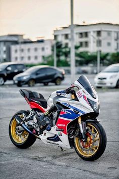 a red, white and blue motorcycle parked in a parking lot