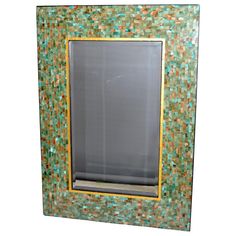 a green and gold mosaic frame with a mirror on the front, against a white background