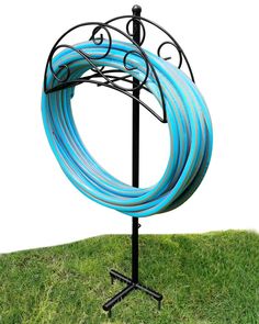 a blue hose on a black stand in the grass