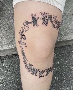 a woman's leg with tattoos on it and cats in the shape of a heart