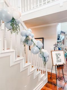 the staircase is decorated with balloons and greenery