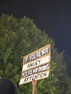 people holding up signs that say if you're not angry, you're not prime attention