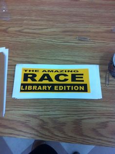 there is a sign that says the magic race library edition on this table next to a pair of scissors