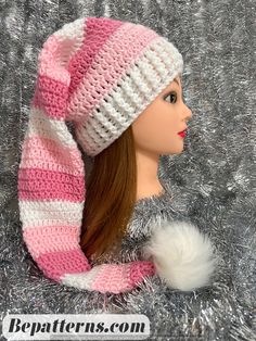 a doll wearing a pink and white knitted hat