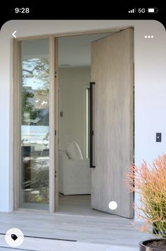 an open door leading to a living room and patio area with potted plants on the side