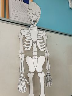 a cut out of a skeleton hanging on a refrigerator