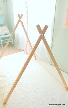 two wooden teepees sitting on top of a bed