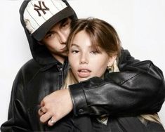 a man and woman hugging each other in front of a white background