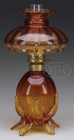 an old fashioned glass oil bottle with a gold decoration on the top and bottom part