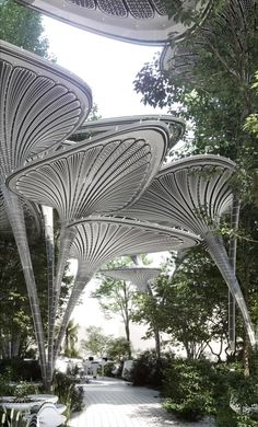 an artisticly designed walkway in the middle of a park with lots of trees and benches