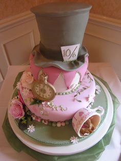 a pink cake with a hat and clock on top