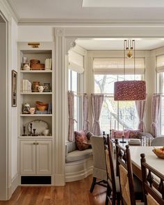 a dinning room table and chairs in front of a window