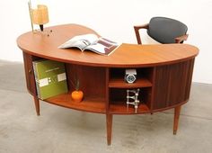 a wooden desk with a book on it and a chair in the corner next to it