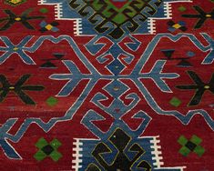 an old red rug with blue and green designs on it