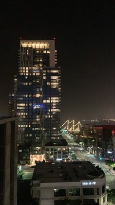 the city is lit up at night with lights on and buildings in the foreground