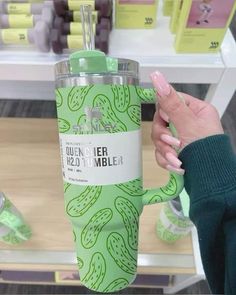 a person holding up a green tumbler cup