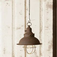 an old fashioned light hanging from a chain