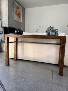 a table with two vases sitting on top of it next to a couch in a living room