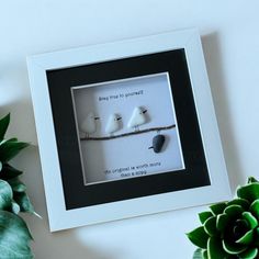 two birds sitting on a branch in a white frame with a black border around it