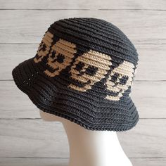 a crocheted skull and crossbones hat on a mannequin head