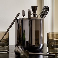 an assortment of kitchen utensils and glasses on a table