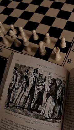 an open book sitting on top of a chess board