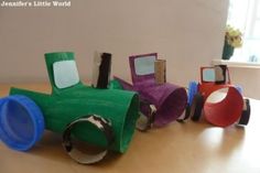 three different colored construction vehicles sitting on top of a wooden table