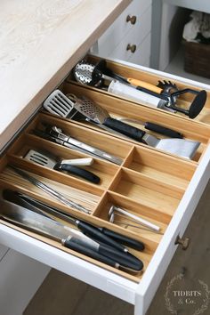 a drawer with utensils in it and some knives on the bottom one side