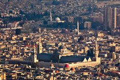 an aerial view of a large city with many tall buildings and some very big towers