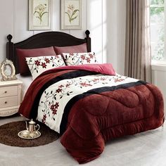 a bed with red and black comforters in a bedroom