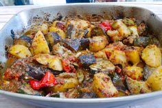 a pan filled with cooked vegetables on top of a wooden table