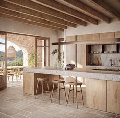 a kitchen with an island counter and stools in front of the sink, next to a dining room table