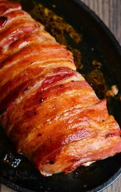 ham wrapped in bacon is cooking in a skillet on the stove top, ready to be cooked