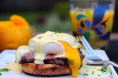 an egg benedict is on top of a piece of toasted bread with cheese and sauce