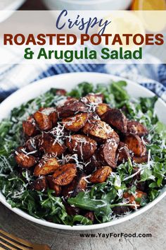 roasted potatoes and arugula salad in a white bowl with parmesan cheese on top