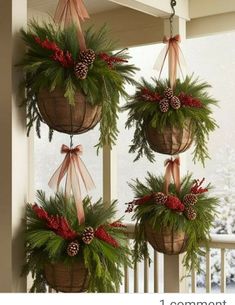 three hanging baskets filled with pine cones and evergreens on the front porch for christmas decorations