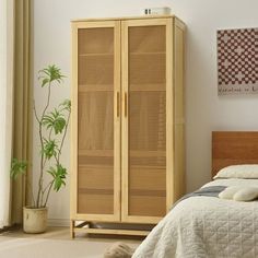 a bed room with a neatly made bed and a tall wooden cabinet next to it